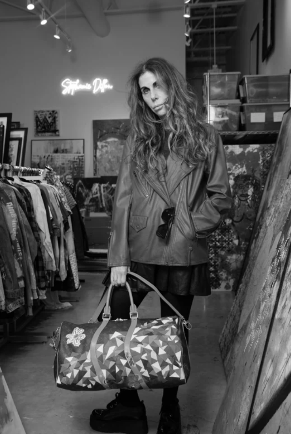 Stephanie Dillon, multidisciplinary mixed-media artist, standing in her studio surrounded by original artworks.